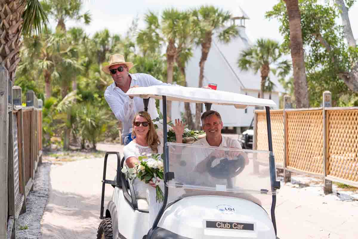 bride and groom in golf cart having fun as they leave the chapel