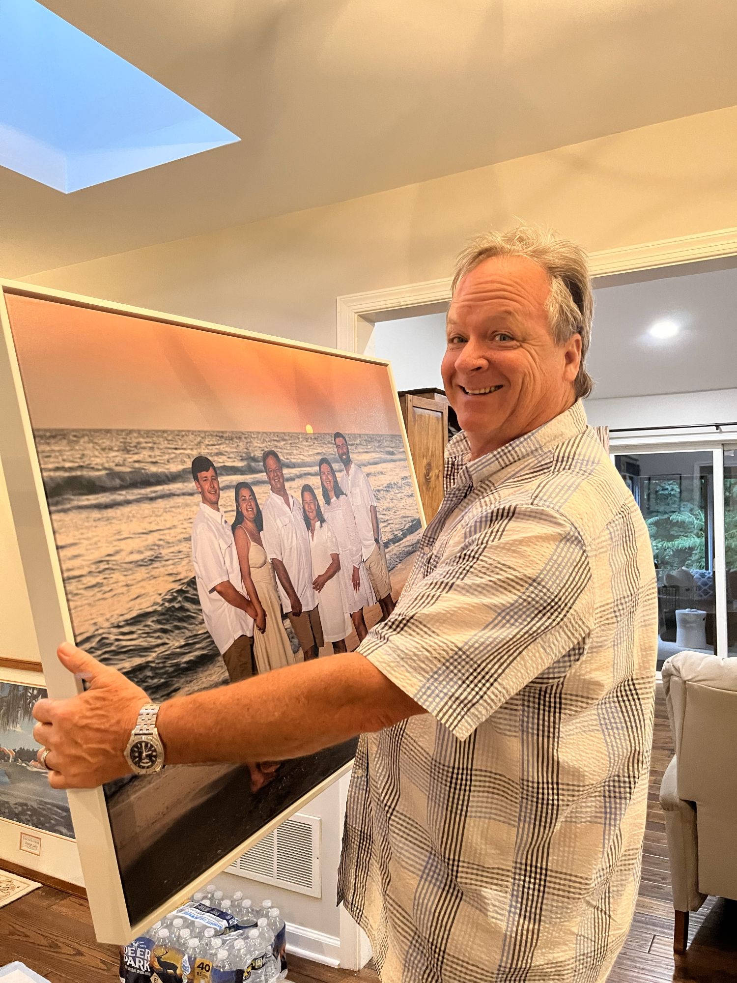 man holding canvas in a float frame