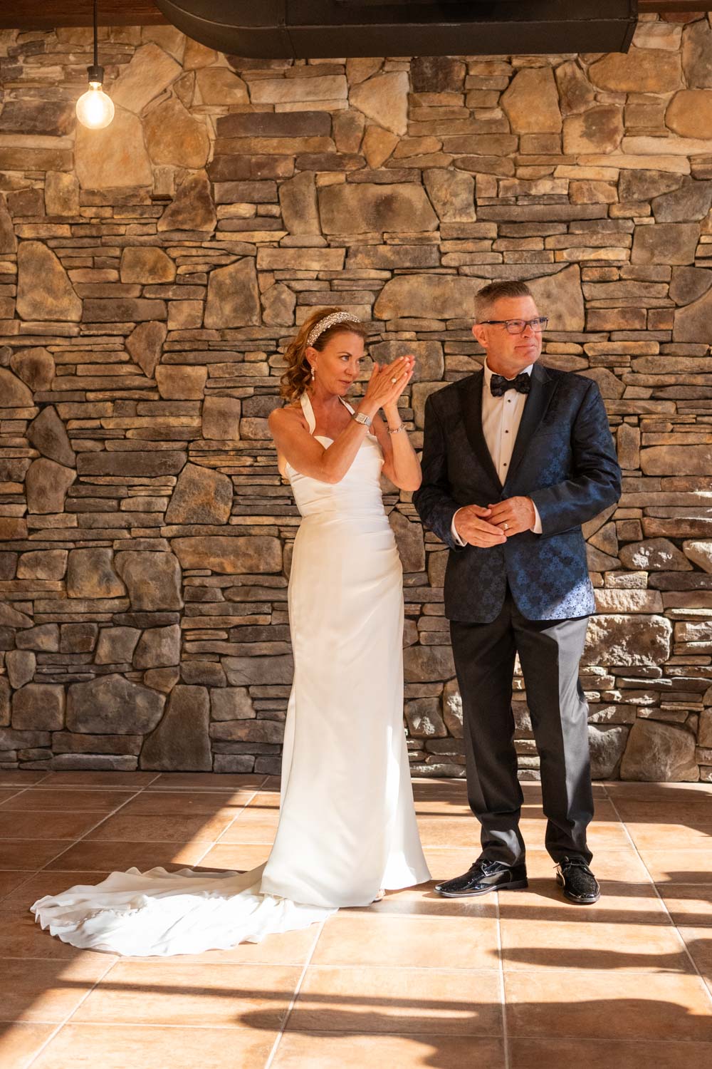 bride and groom look out the window and clap