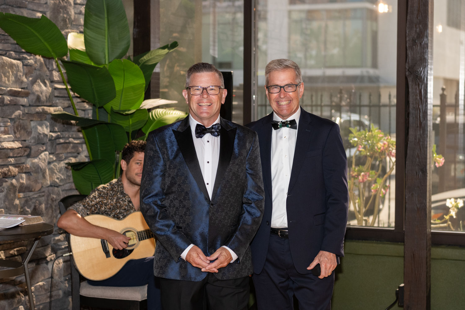 groom stands smiling with his best man as his bride enters