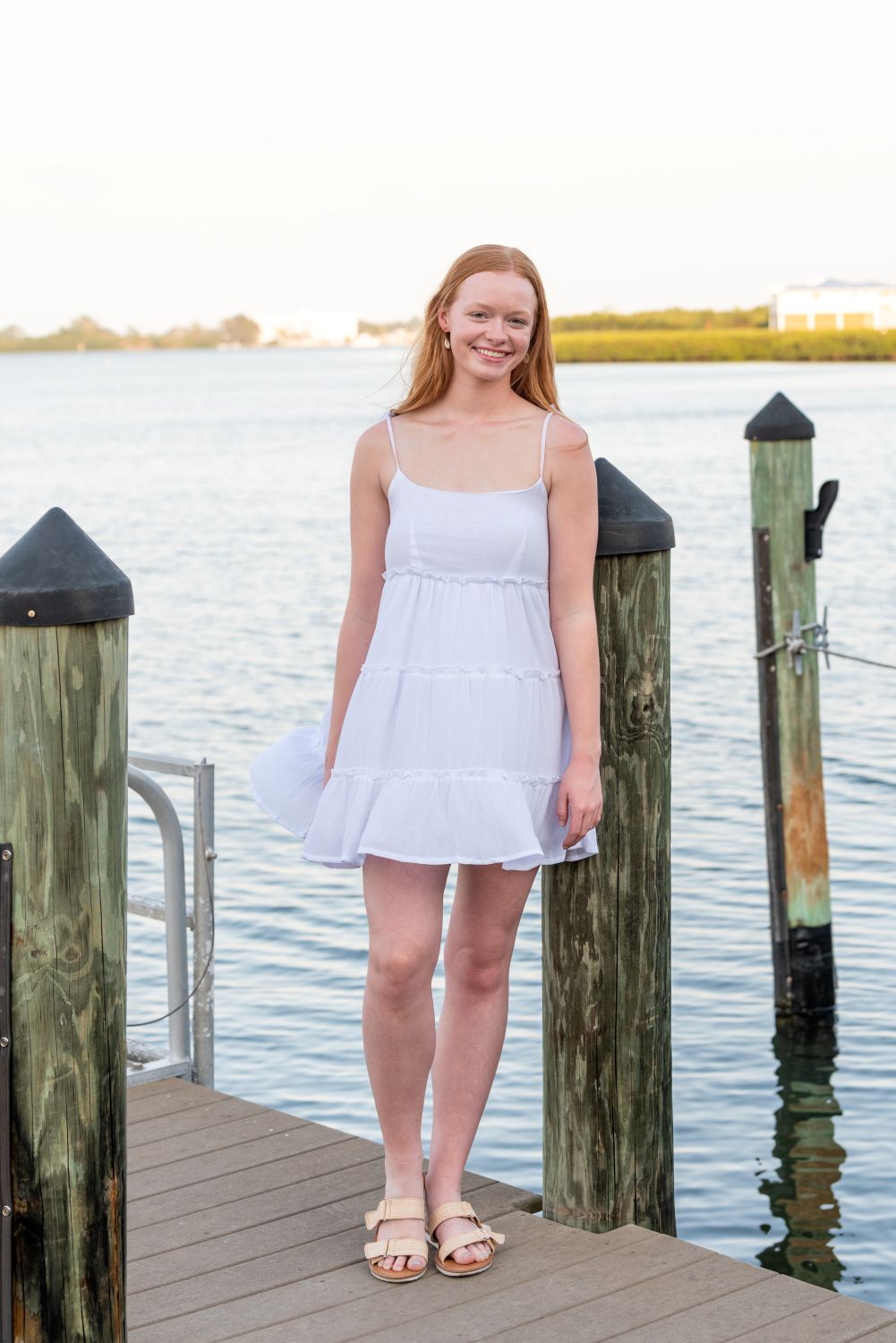 senior photo of girl leaning against dock piling