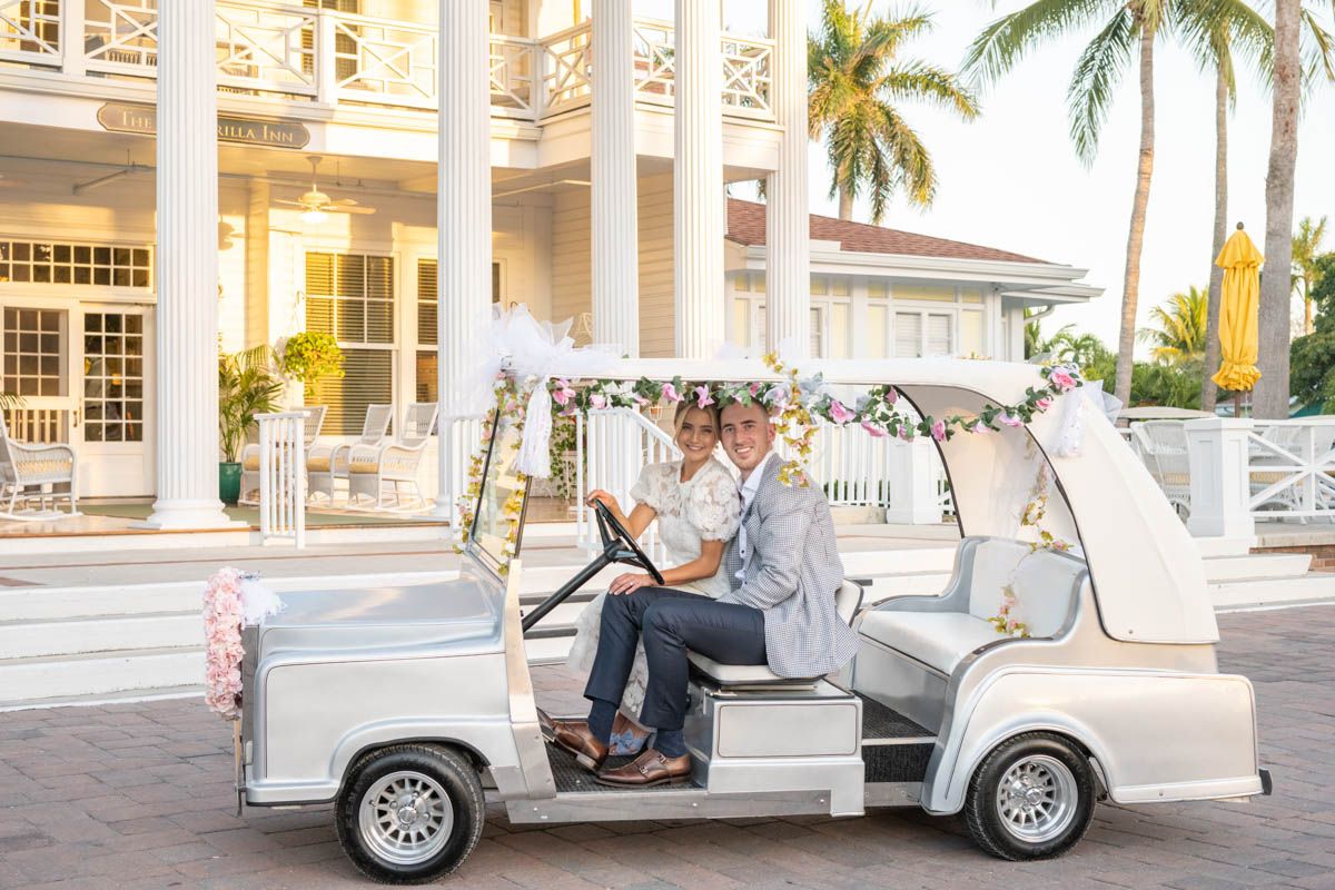 couple in decorated golf cart in front of Gasparilla Inn