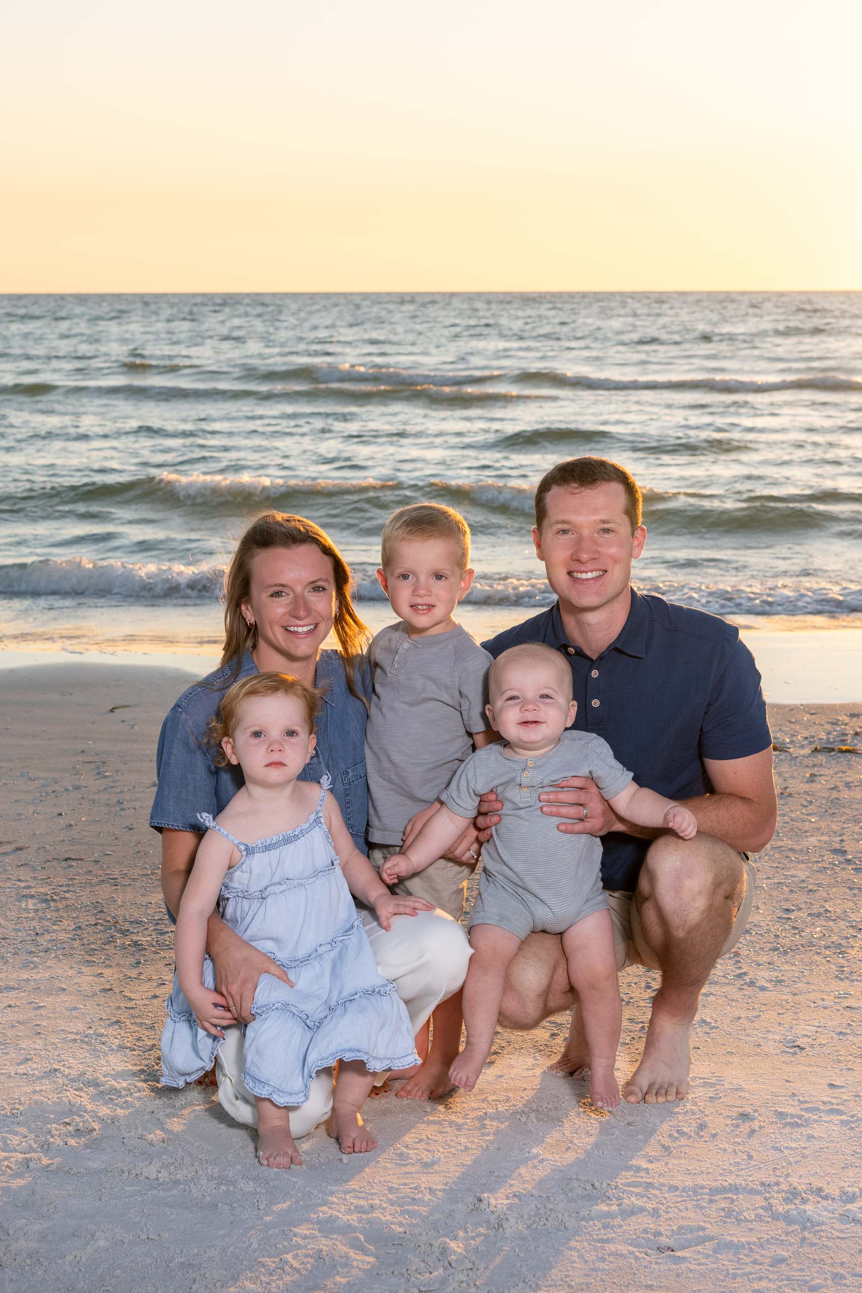 young parents with three children on Siesta Key beach at sunset