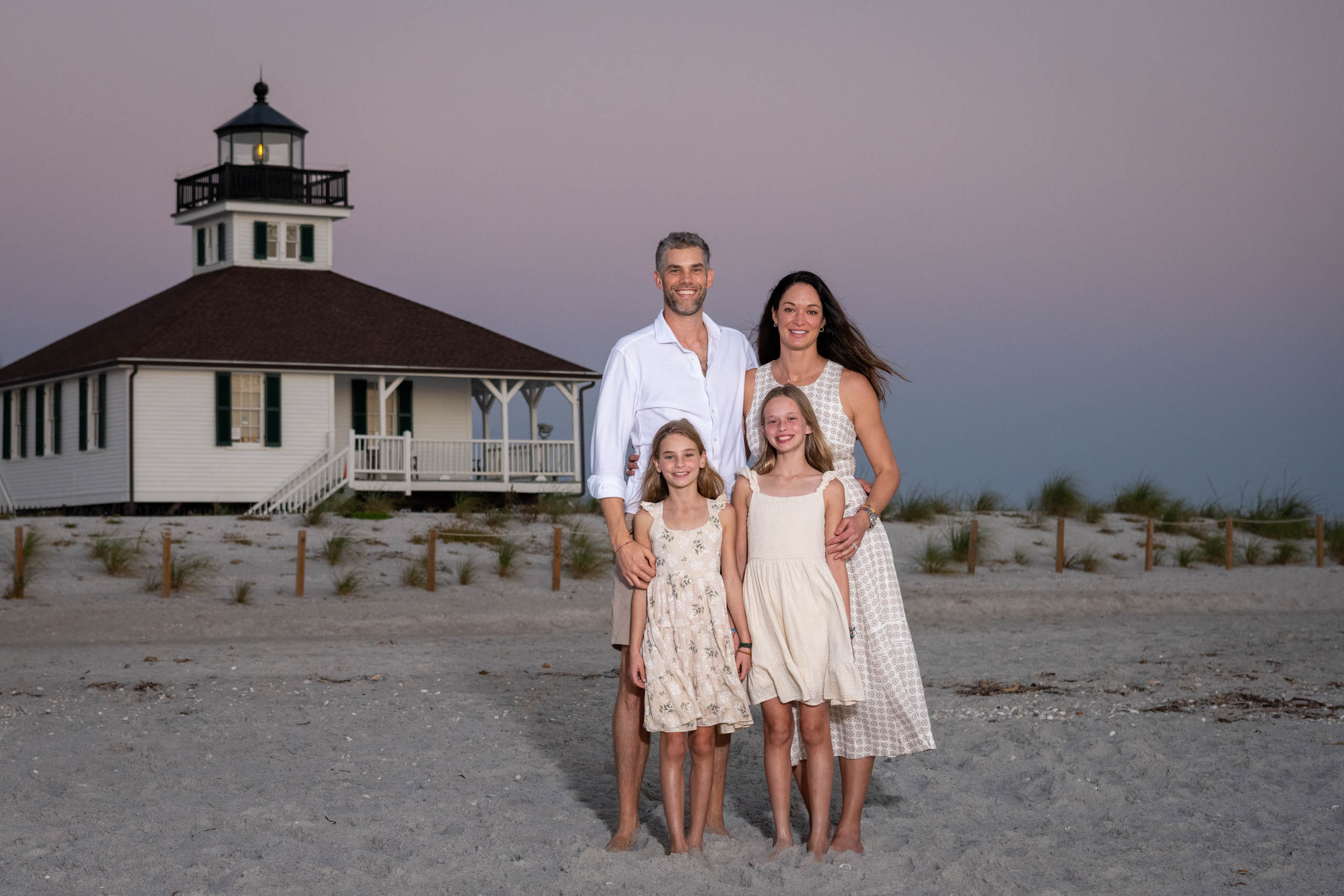 family in front of the Boca Grande lighthouse after sunset