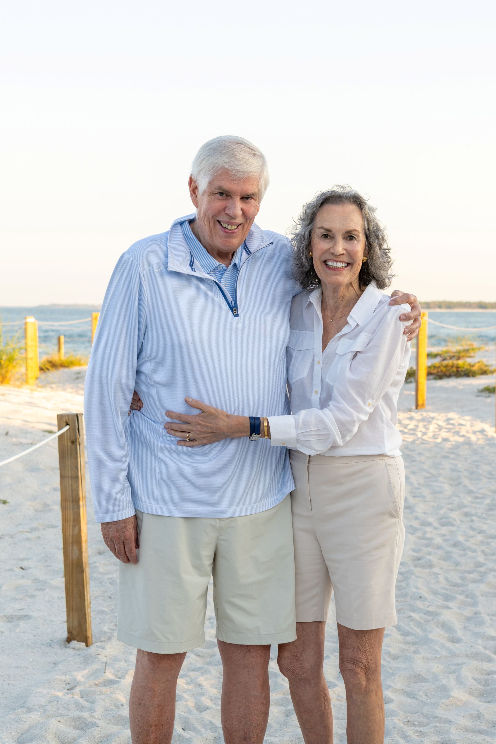 grandparents holding each other and smiling while on the beach
