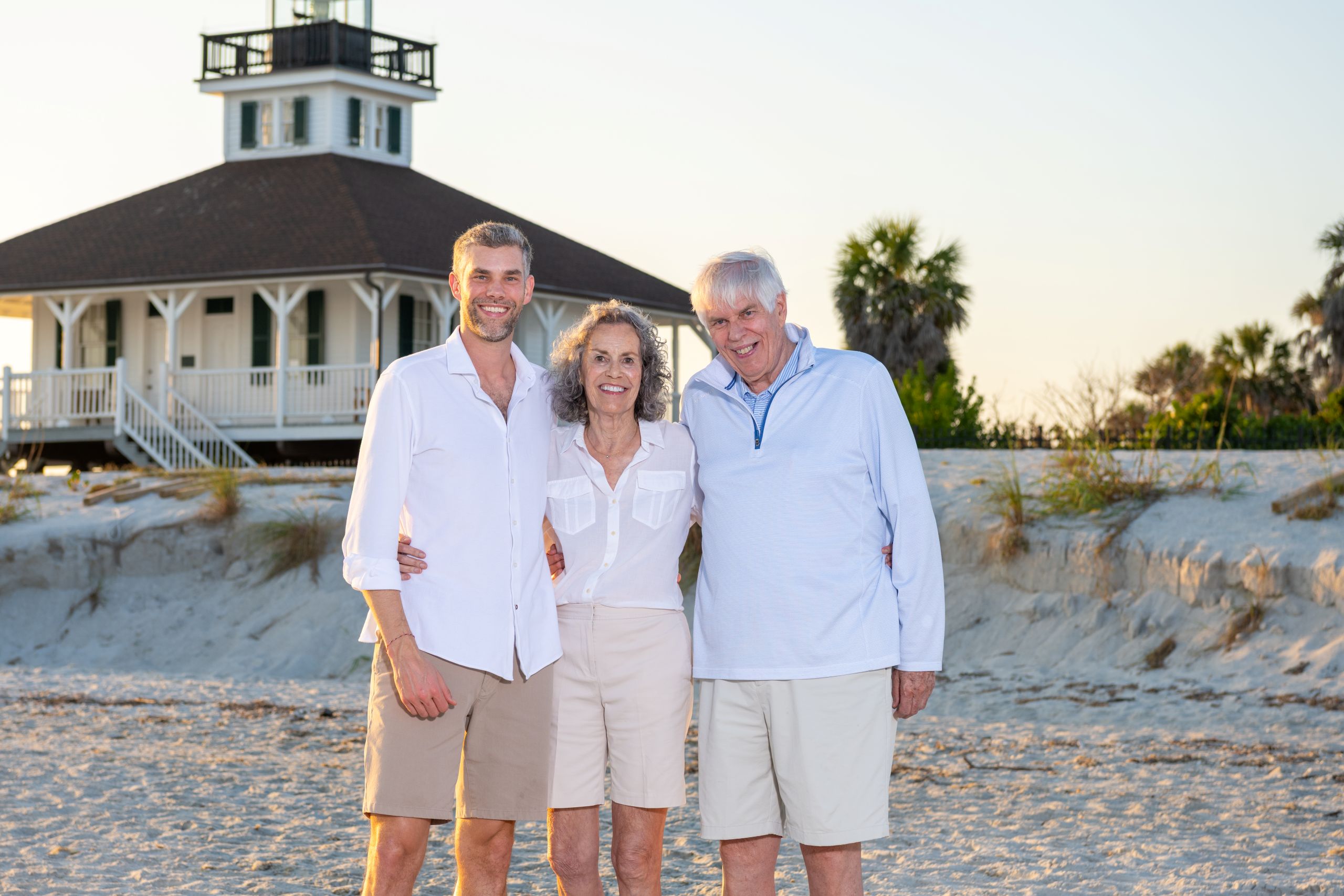 adult son with his parents with the Boca Grande lighthouse in the background