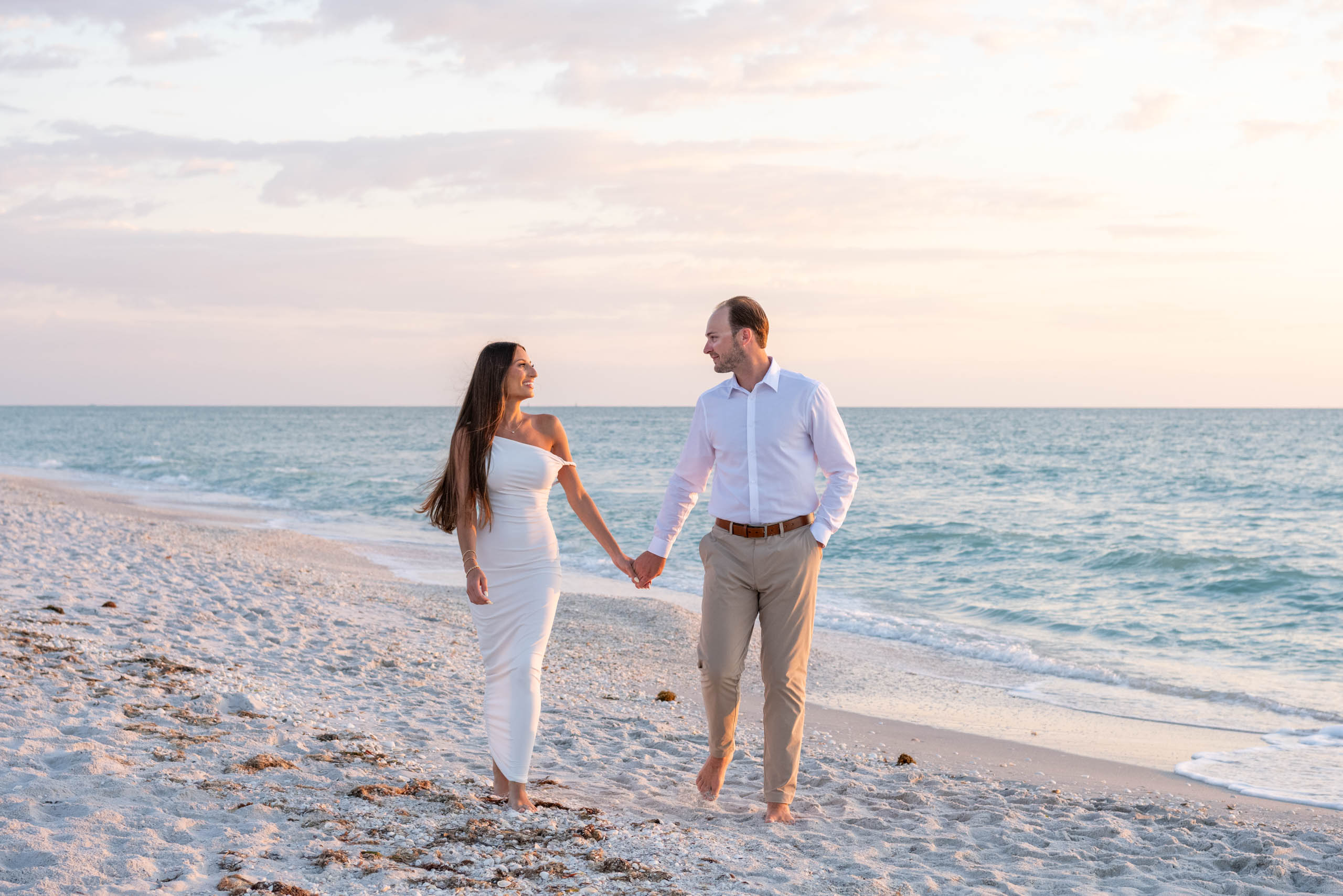couple walk along beach on Boca Grande at sunset