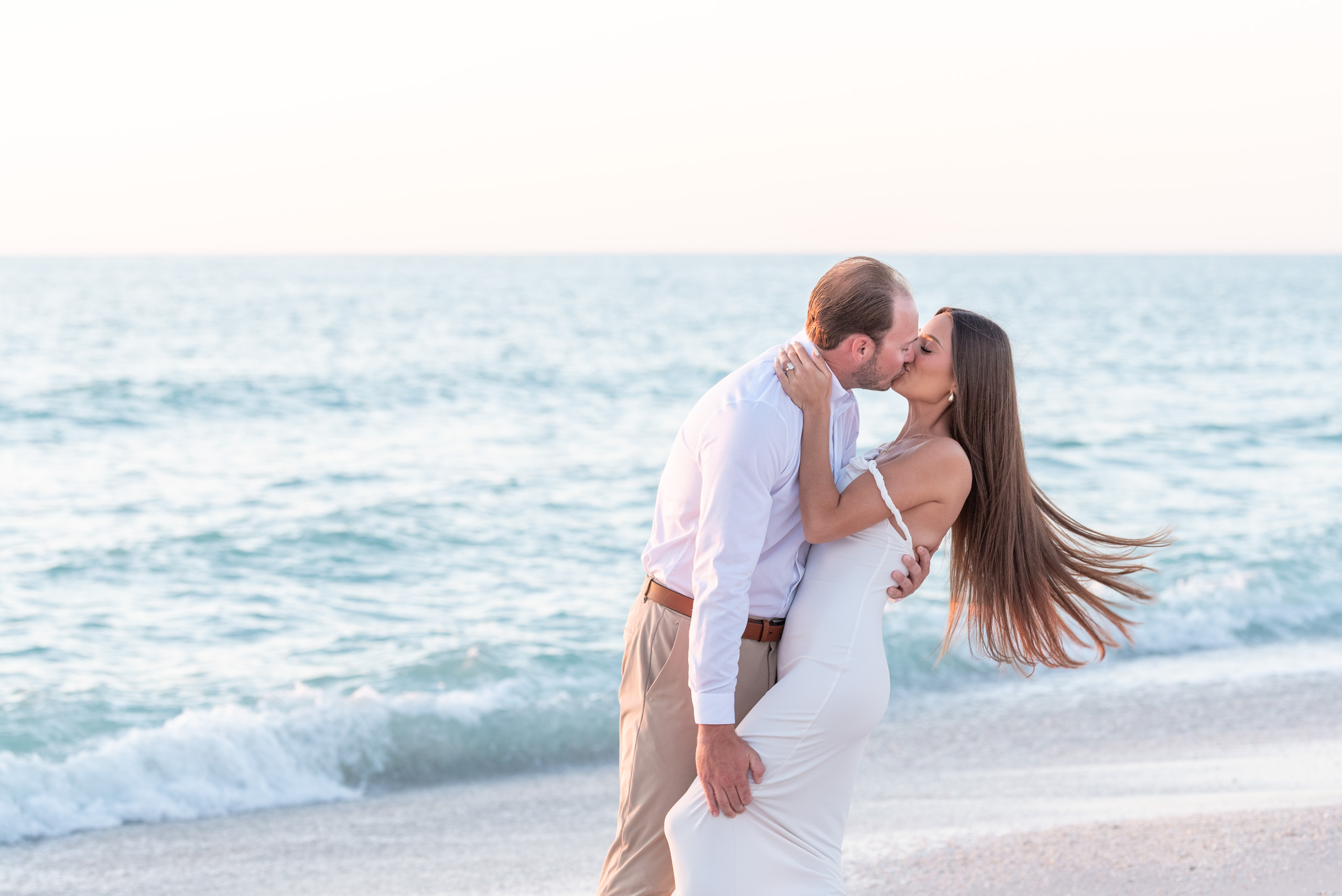 man dips his fiance and her hair blows behind her