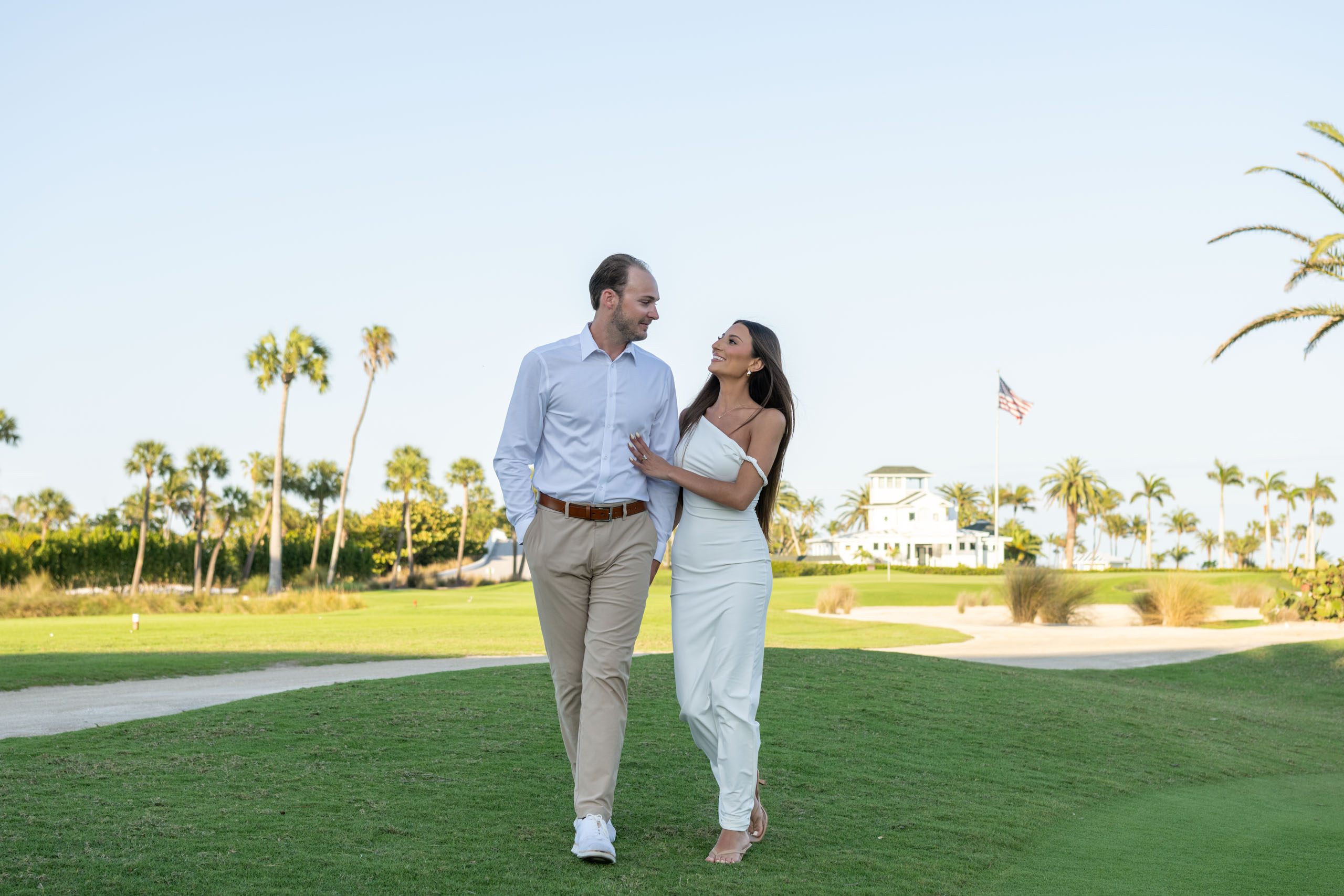 newly engaged couple walk along the golf course behind the Gasparilla Inn