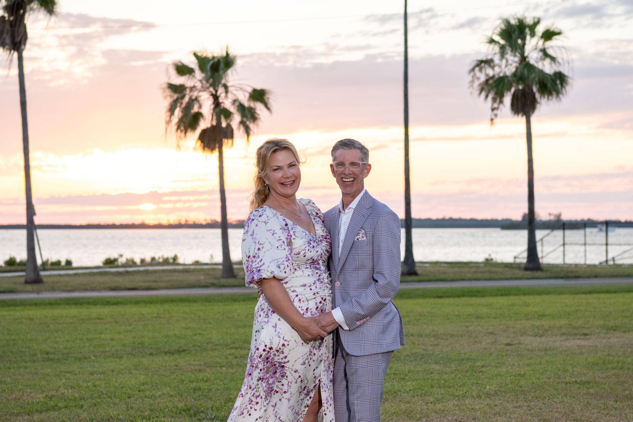 bride and groom laugh as they hold hands with the Tampa Bay in the background during a break from their wedding reception at the Fenway Hotel